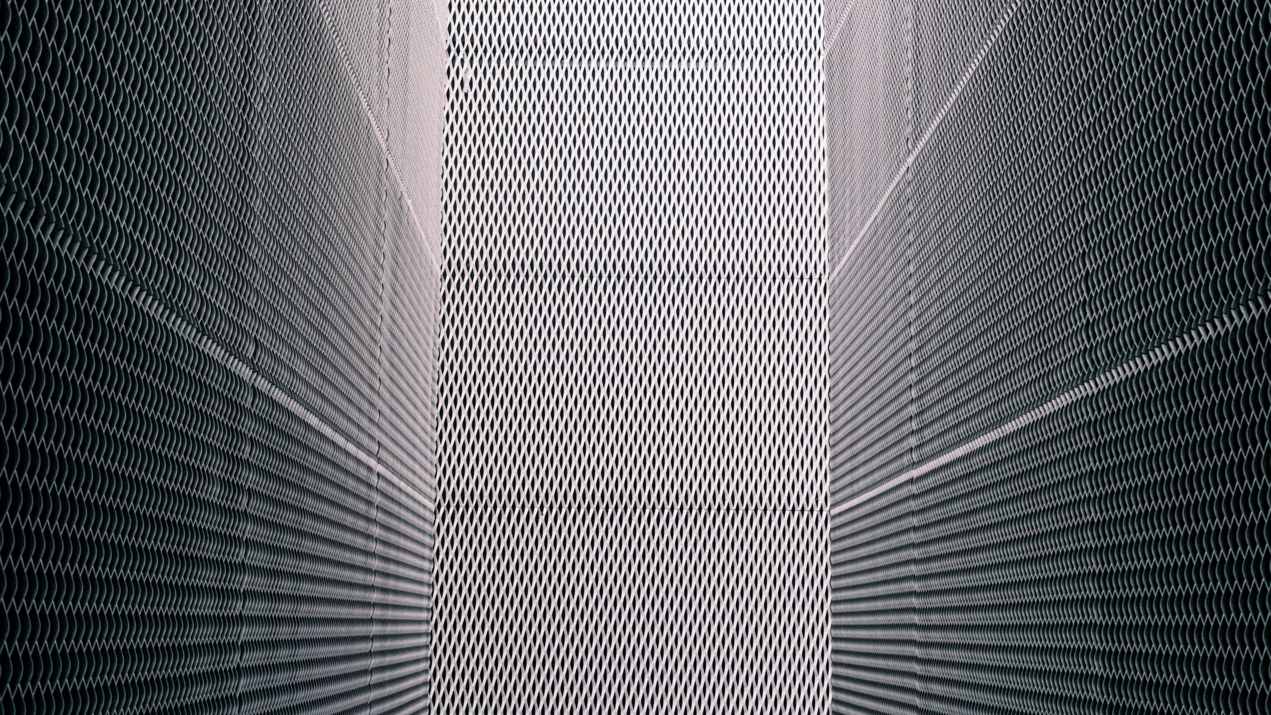 Symmetrical view of metal grates creating an abstract geometric pattern.