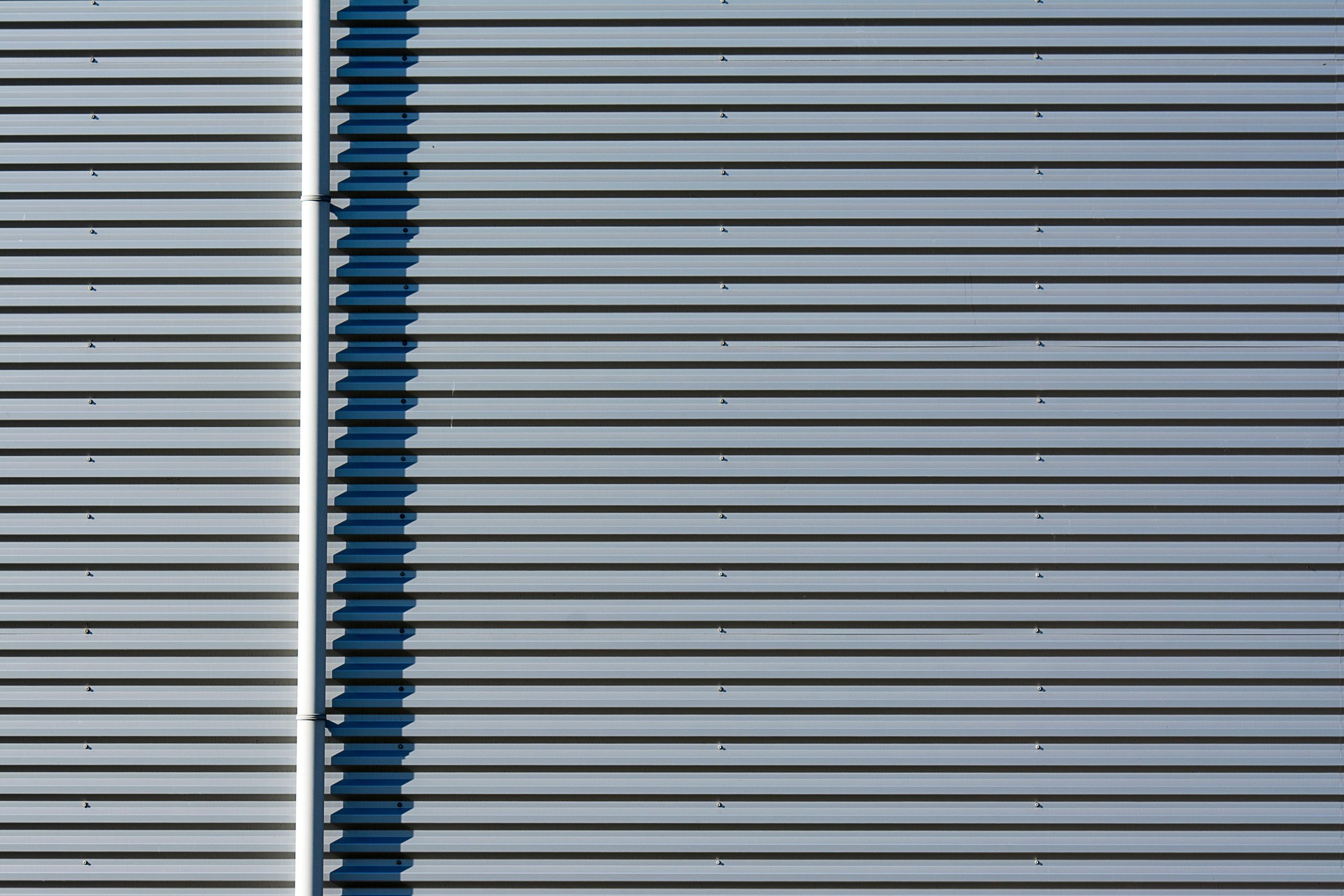 Close-up of a modern industrial metal facade highlighting its linear patterns.